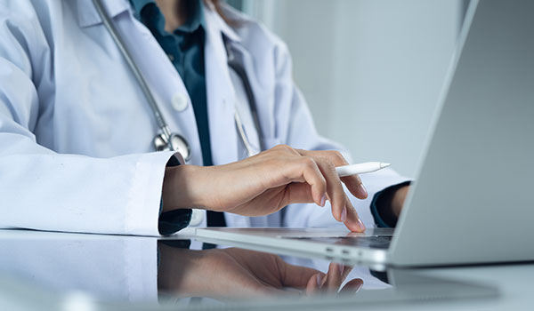 Doctor typing on laptop