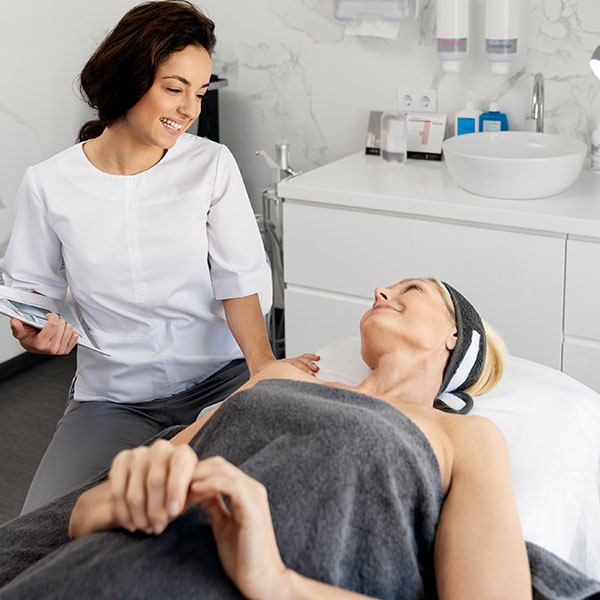 Health Practitioner with patient who is laying on a table wrapped in sheet